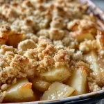 Close-up of a warm apple cinnamon crumble with a golden-brown topping.