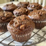 Close-up view of a freshly baked espresso muffin with chocolate chunks and walnuts.