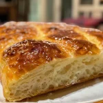 A close-up view of a braided Hefekranz bread with a golden crust.