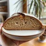 A close-up of a slice of Herbstliches Kürbisbrot showcasing its moist texture and pumpkin seeds.