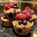 Side view of golden-brown berry muffins with a moist texture.