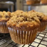 Close-up side view of freshly baked Cinnamon Streusel Muffins with a golden-brown top and crumbly streusel topping.
