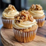 Close-up view of a Nuss Cupcake with nuts on top and a moist texture.